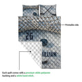 Close view of hockey quilt blanket showing printable blue artwork, crossed sticks, puck, and quilted backing