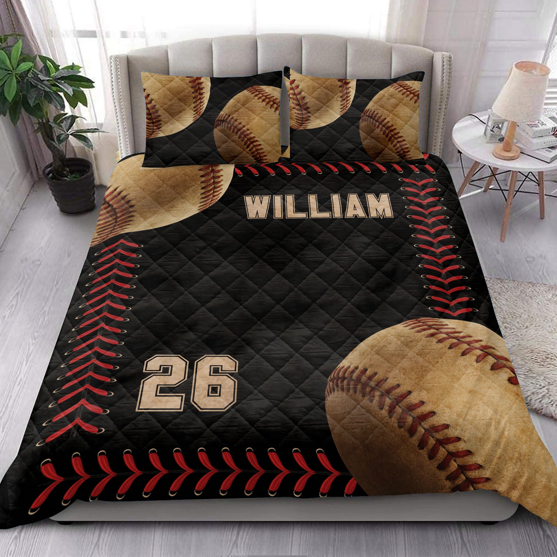 Baseball quilt blanket styled in a bright bedroom with baseball pillows, black bedding, and red stitching accents