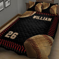 Close bedroom view of a black baseball quilt blanket with oversized baseballs, red stitching, and bold sports graphics