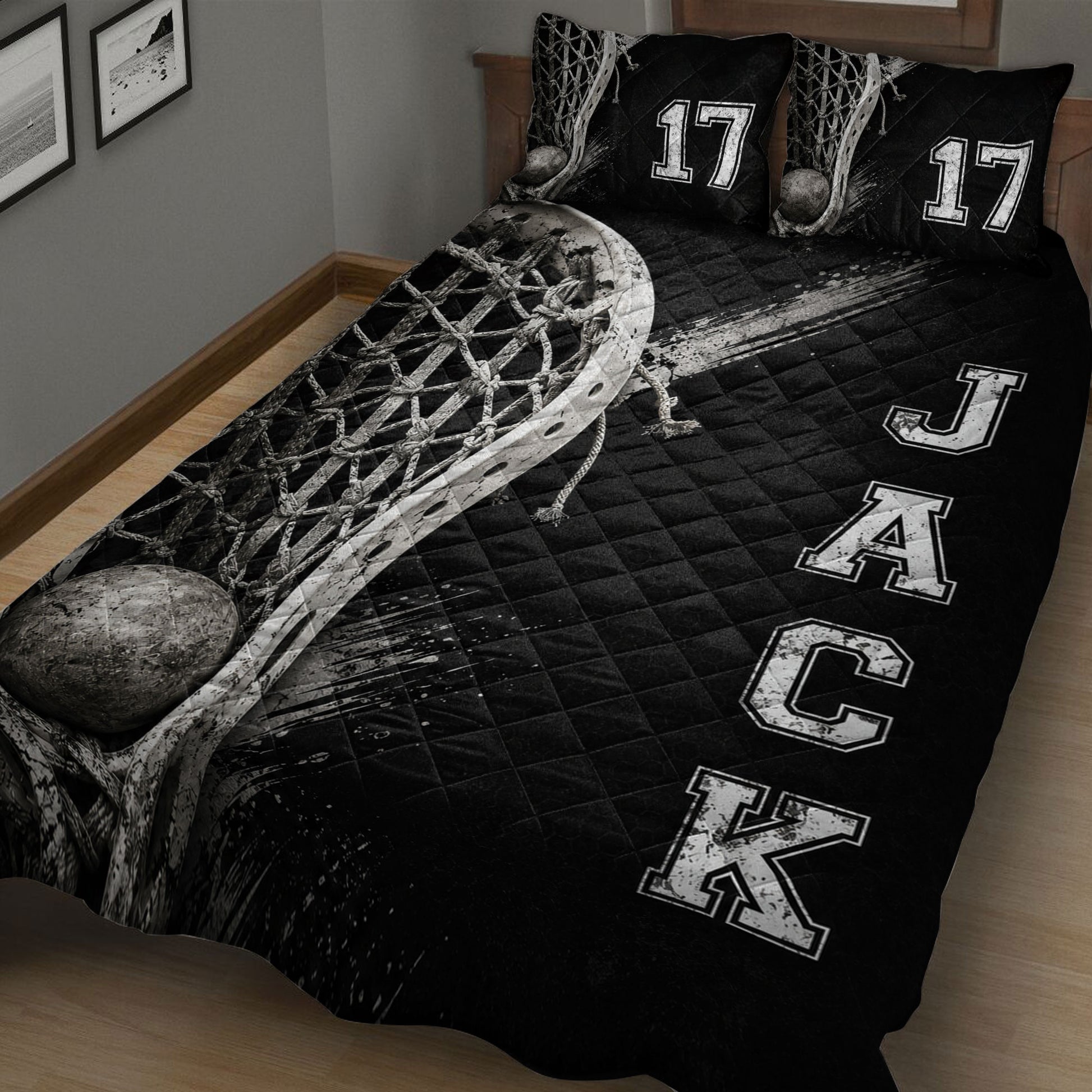 Close view of black lacrosse bedding with a large stick, net, ball, and distressed sports graphic design