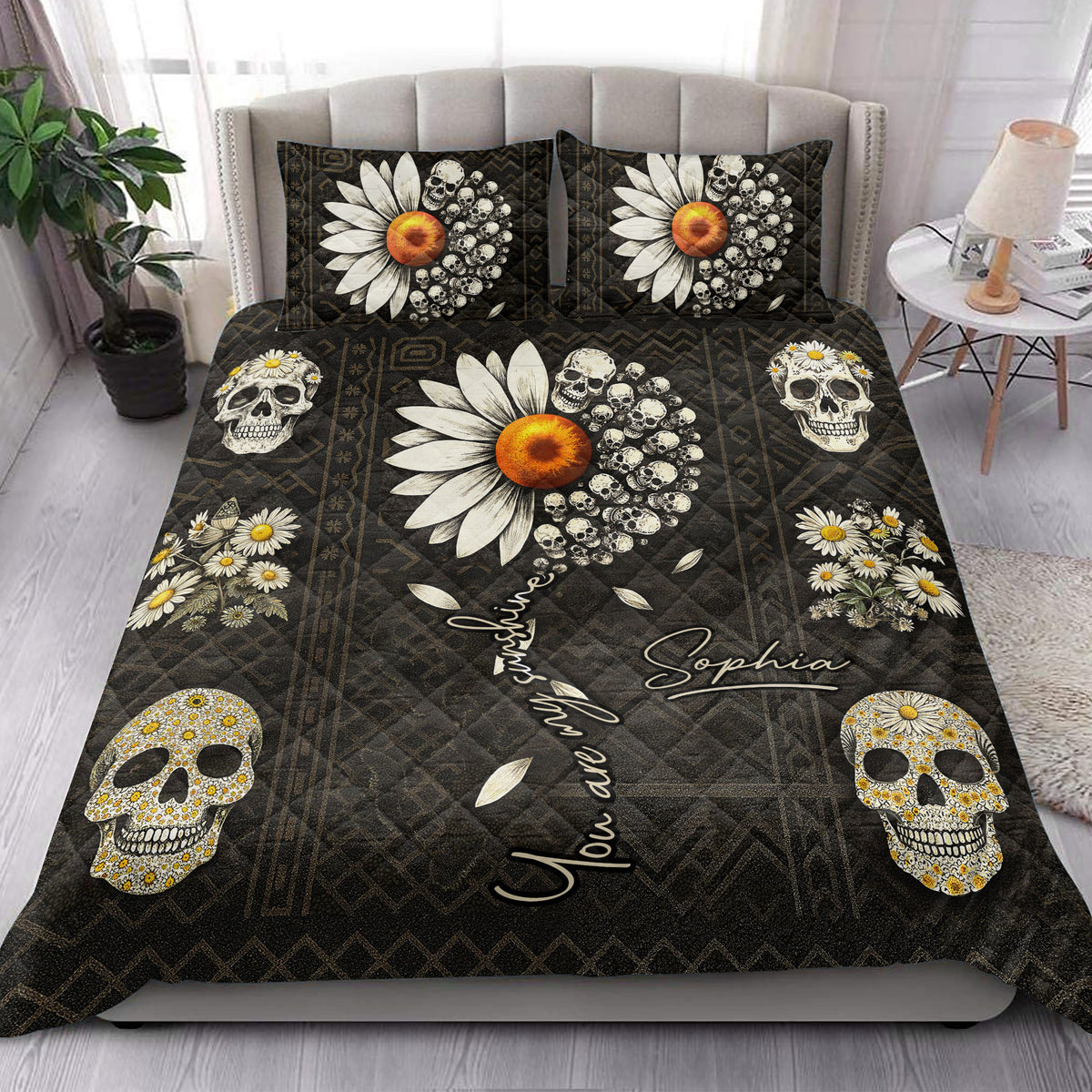 Gothic skull quilt blanket styled on a bedroom bed with daisy-covered skulls and dark geometric patterns