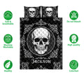 Black and white skull quilt bedding set shown flat with ornate gothic scrollwork and coordinated pillow designs