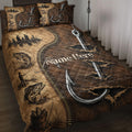 Fishing quilt blanket displayed on a bed with fish, anglers, lakeside scenes, and large fishing hook artwork