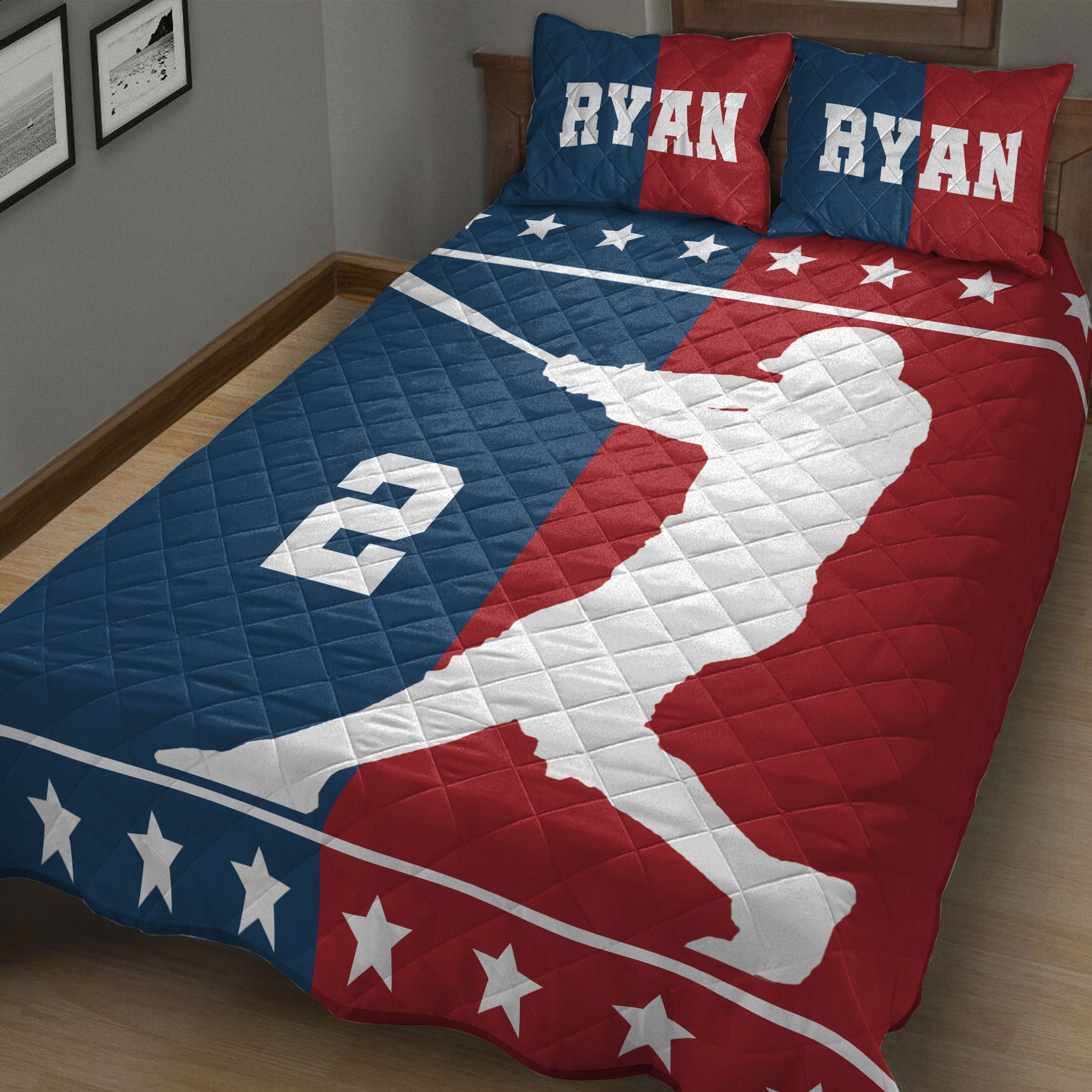 Close bedroom view of a baseball quilt blanket featuring a batter silhouette, stars, and bold sports colors