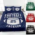 Navy football quilt blanket displayed on a bed with football graphics and coordinating pillow designs