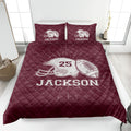 Maroon football quilt blanket featuring helmet and football artwork in a bedroom setting