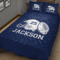 Close bedroom view of a navy football quilt blanket with helmet and football artwork