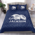 Navy football quilt blanket styled in a bright bedroom with large sports graphics
