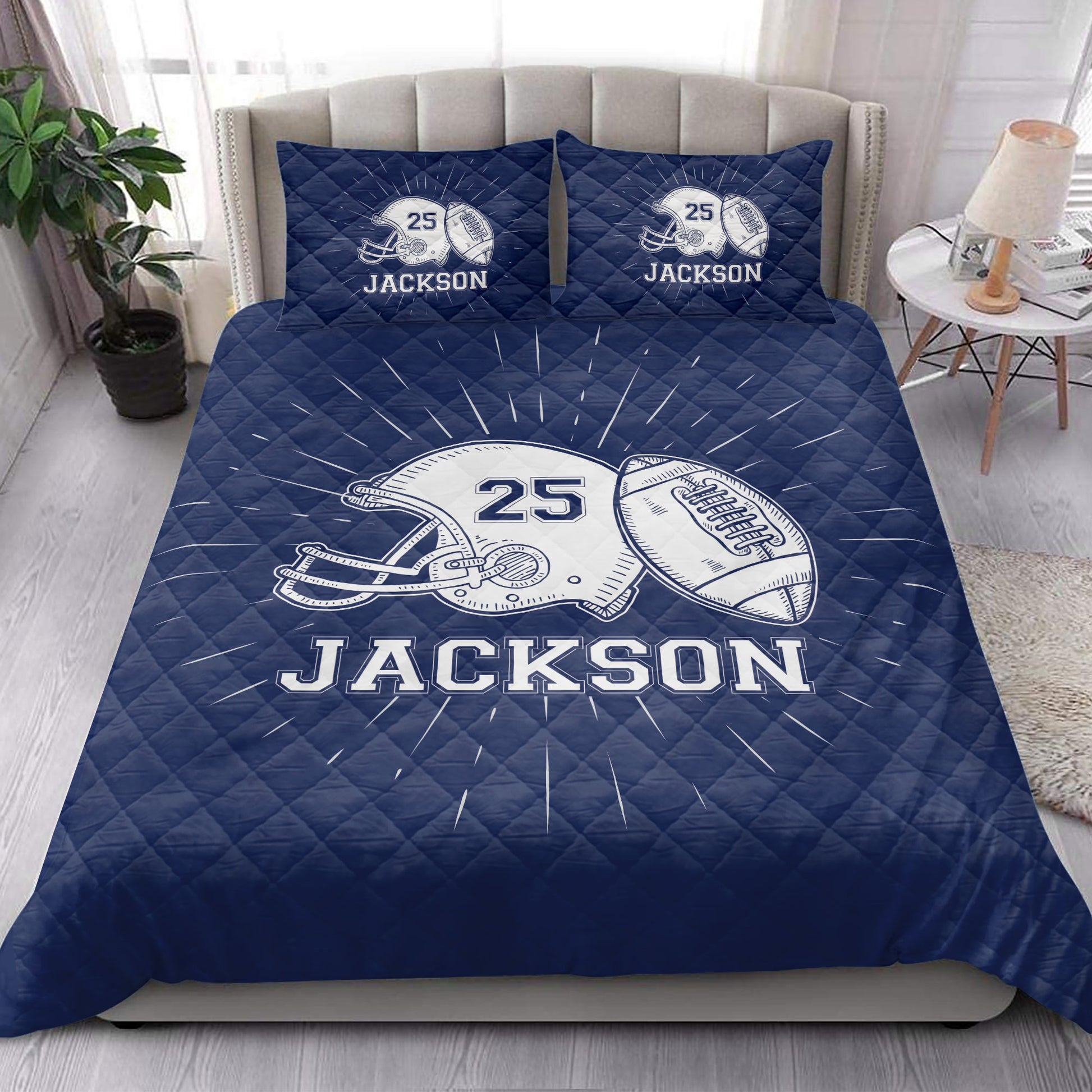 Navy football quilt blanket styled in a bright bedroom with large sports graphics