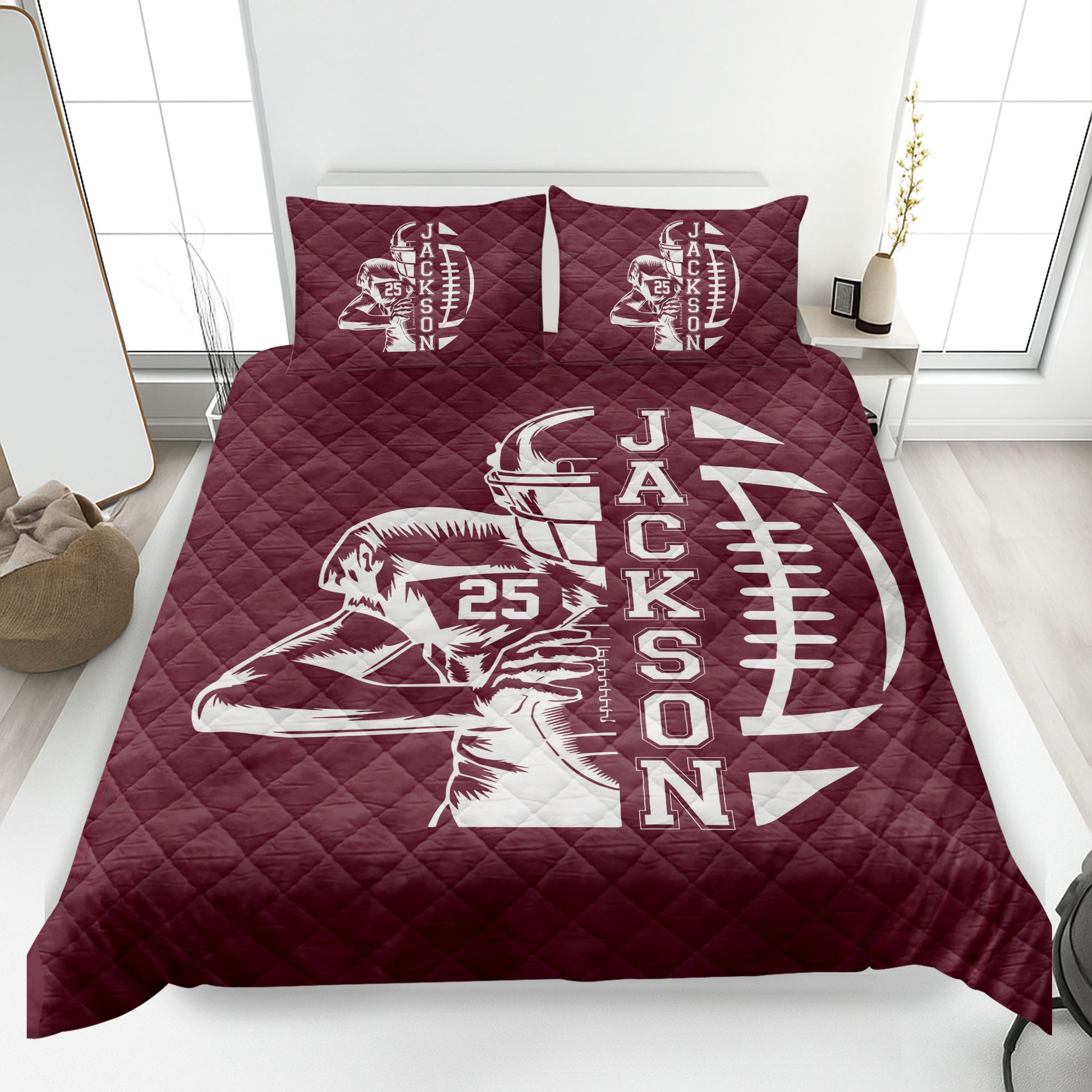 Maroon football quilt blanket shown in a bedroom with player and football design
