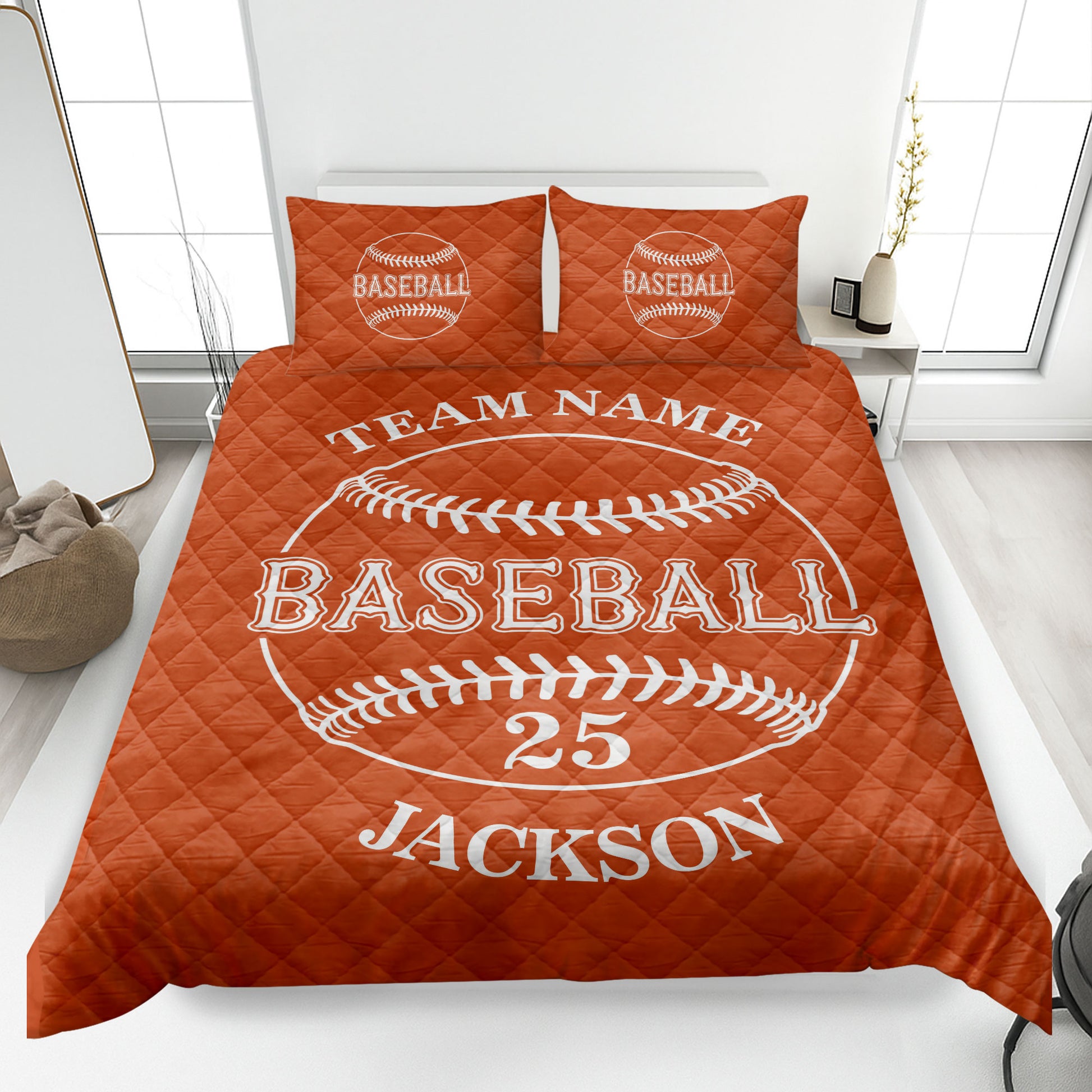Orange baseball quilt blanket shown on a bed with bold baseball graphics and team-themed artwork