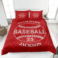 Red baseball quilt blanket displayed on a bed with prominent baseball stitching artwork