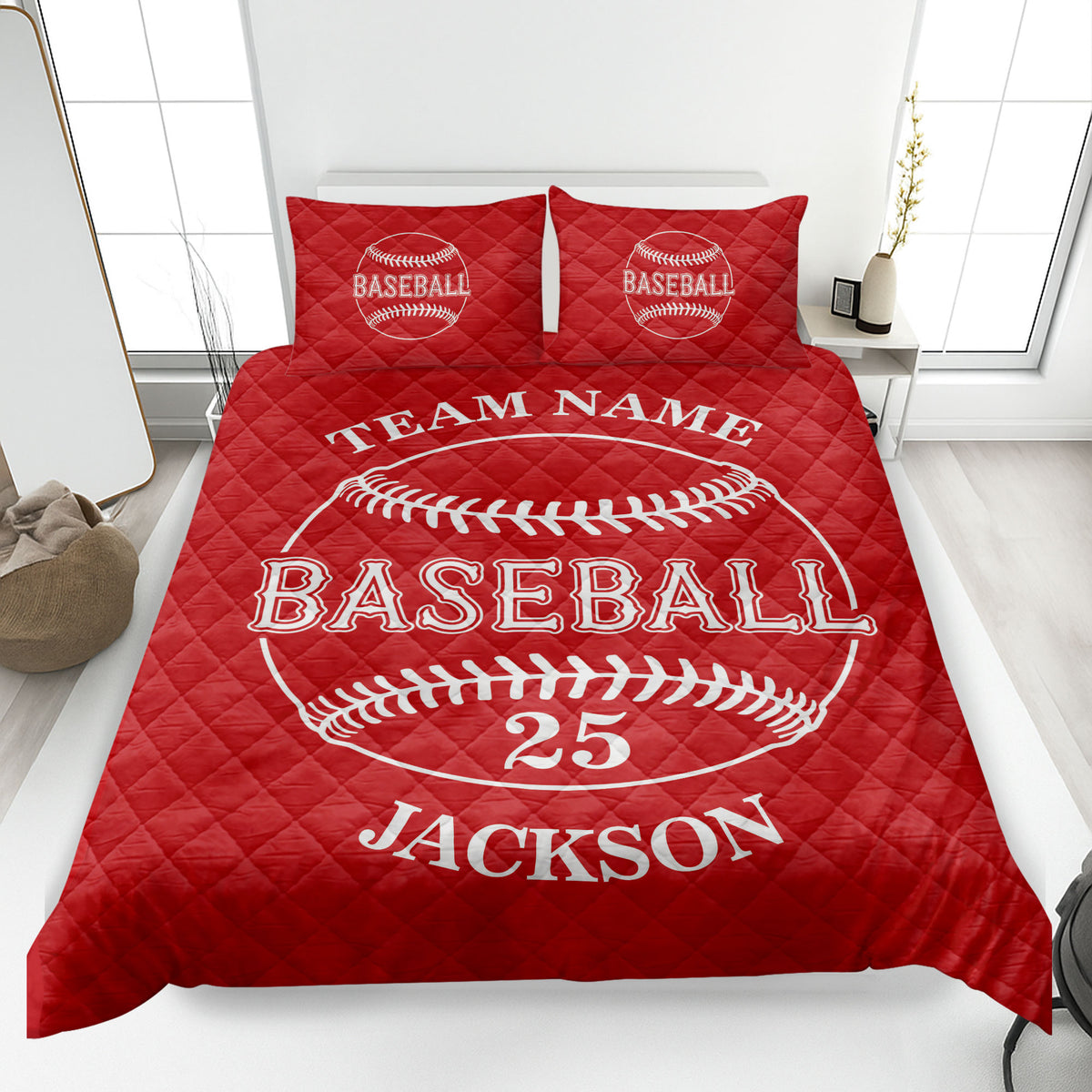 Red baseball quilt blanket displayed on a bed with prominent baseball stitching artwork