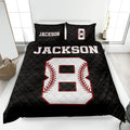 Black baseball quilt blanket on a bed featuring a large white baseball graphic with red stitching