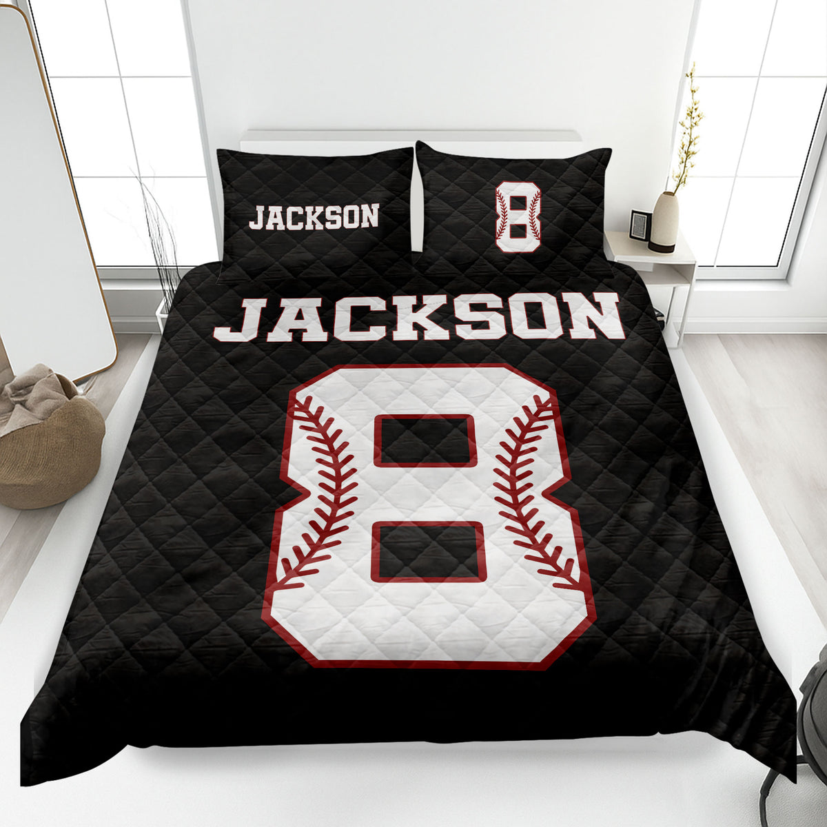 Black baseball quilt blanket on a bed featuring a large white baseball graphic with red stitching