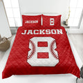 Red baseball quilt blanket displayed on a bed with bold white and red baseball artwork