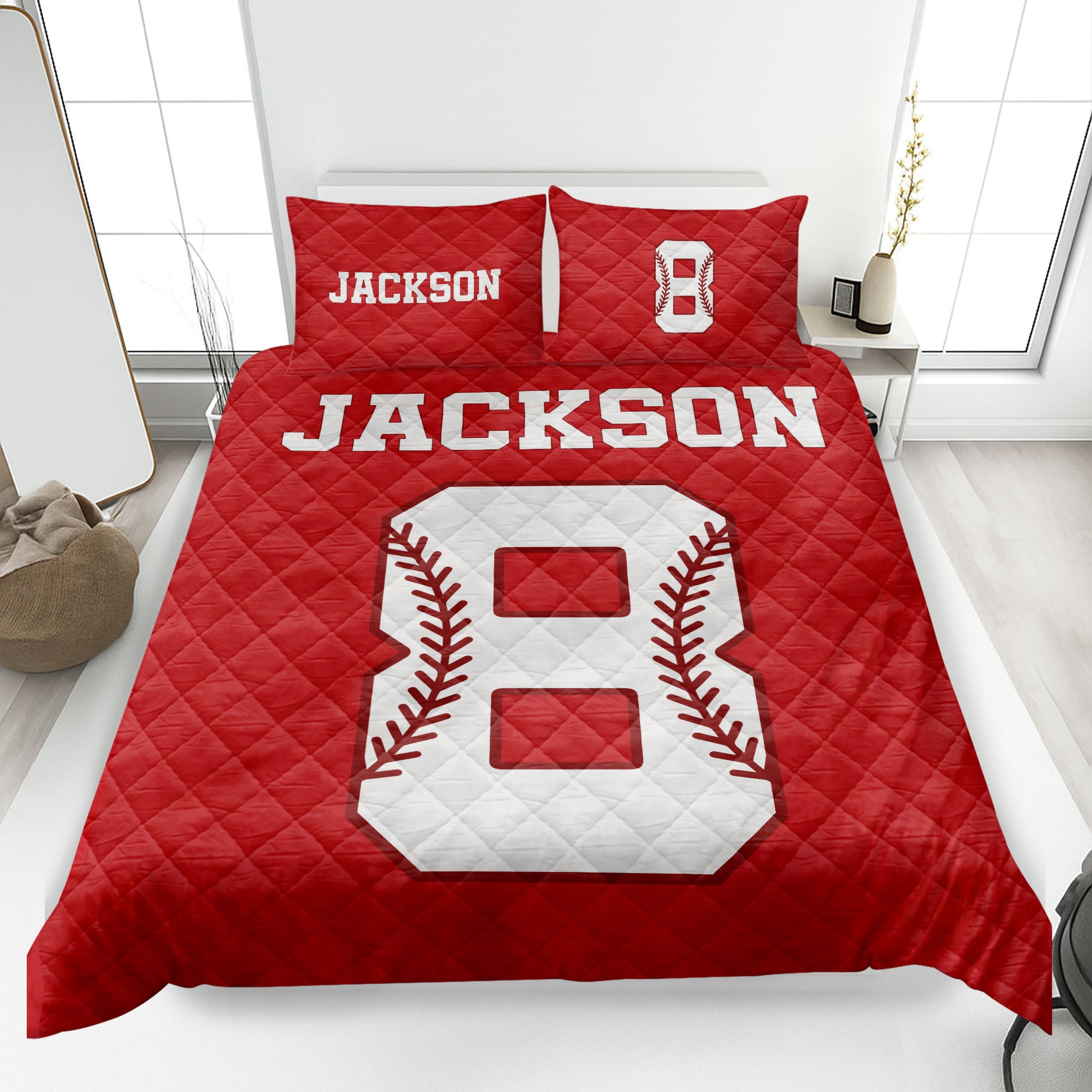 Red baseball quilt blanket displayed on a bed with bold white and red baseball artwork