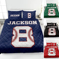 Baseball quilt blanket displayed on a bed with varsity-style artwork and blue, green, black, and red color options