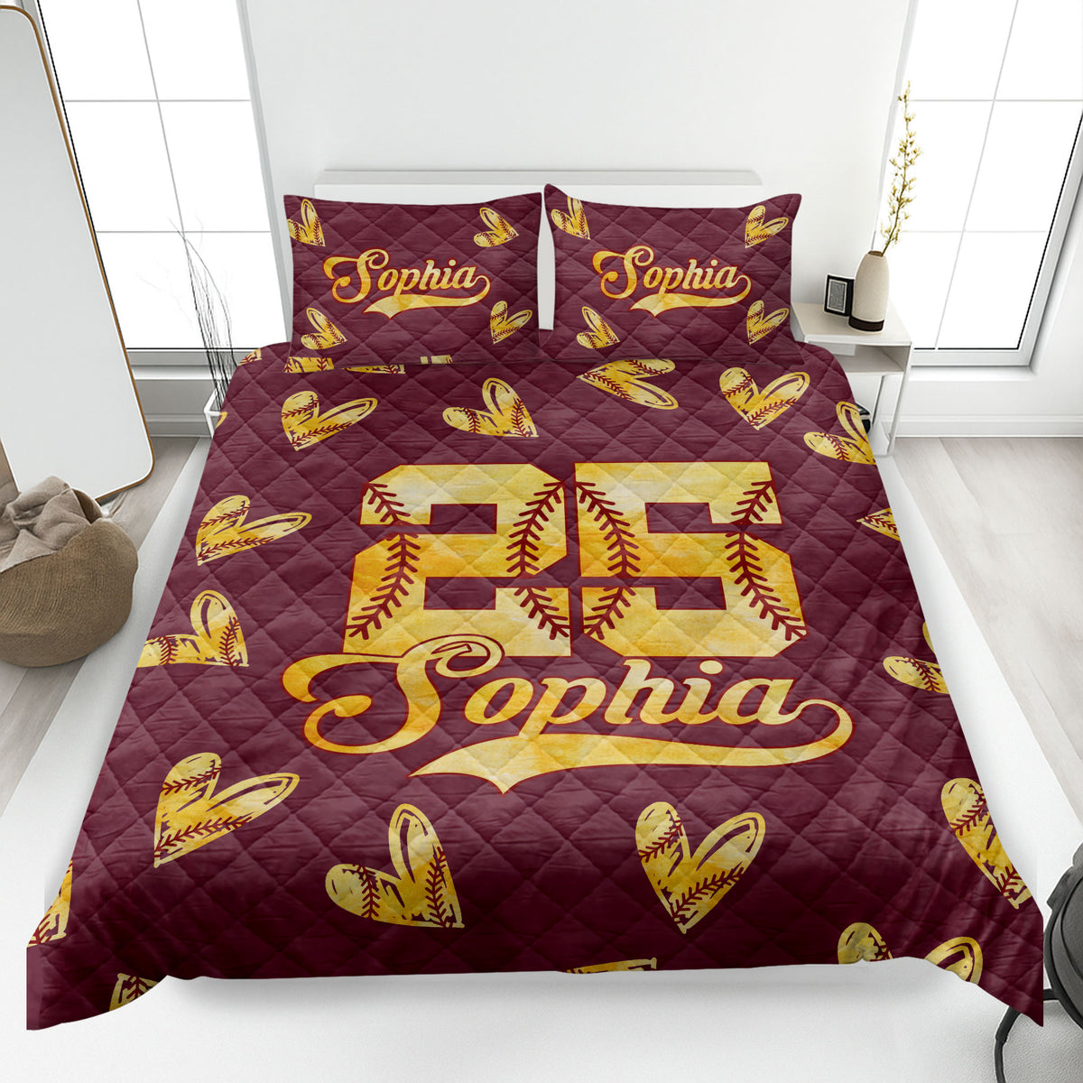 Maroon softball quilt blanket displayed on a bed with golden stitched softball hearts and sporty artwork