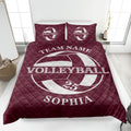 Maroon volleyball quilt blanket shown on a bed with bold white sports graphics and quilted texture