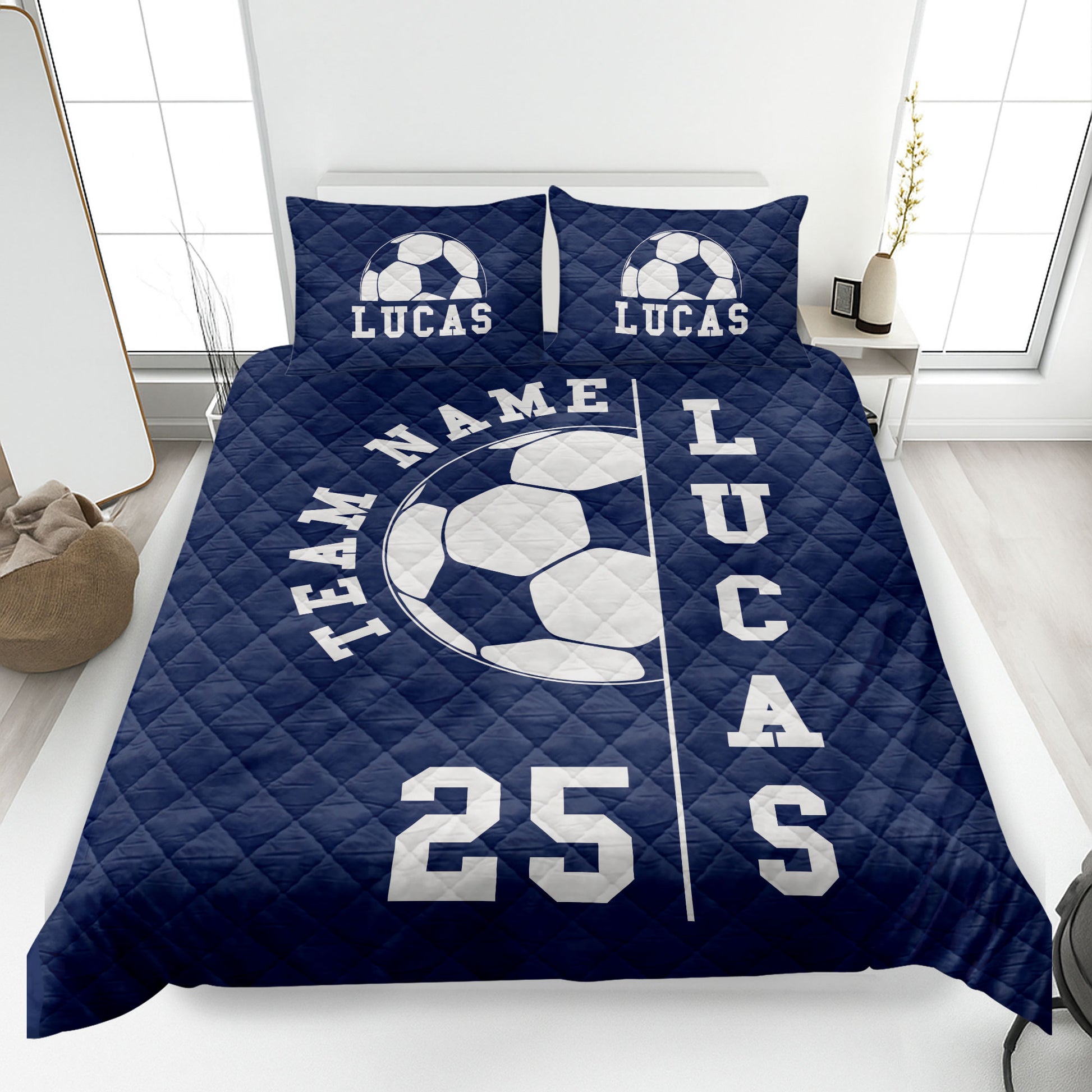 Navy soccer quilt blanket styled on a bedroom bed with large soccer ball artwork