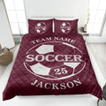 Maroon soccer quilt blanket displayed in a bedroom with large soccer ball artwork