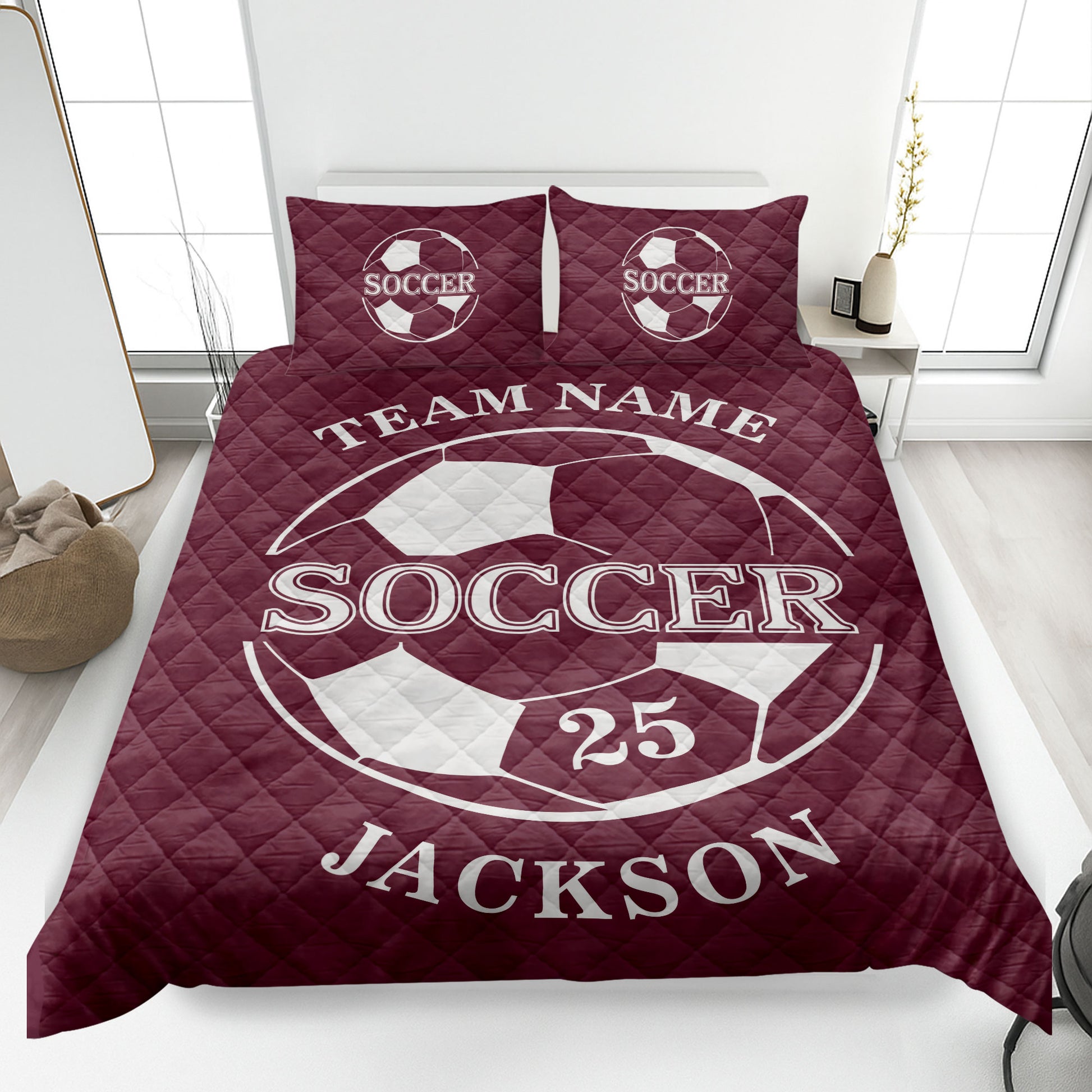 Maroon soccer quilt blanket displayed in a bedroom with large soccer ball artwork