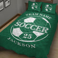 Green soccer quilt blanket styled on a bed with large soccer artwork and quilted diamond texture