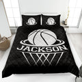 Black basketball quilt blanket styled on a bedroom bed with bold white sports artwork