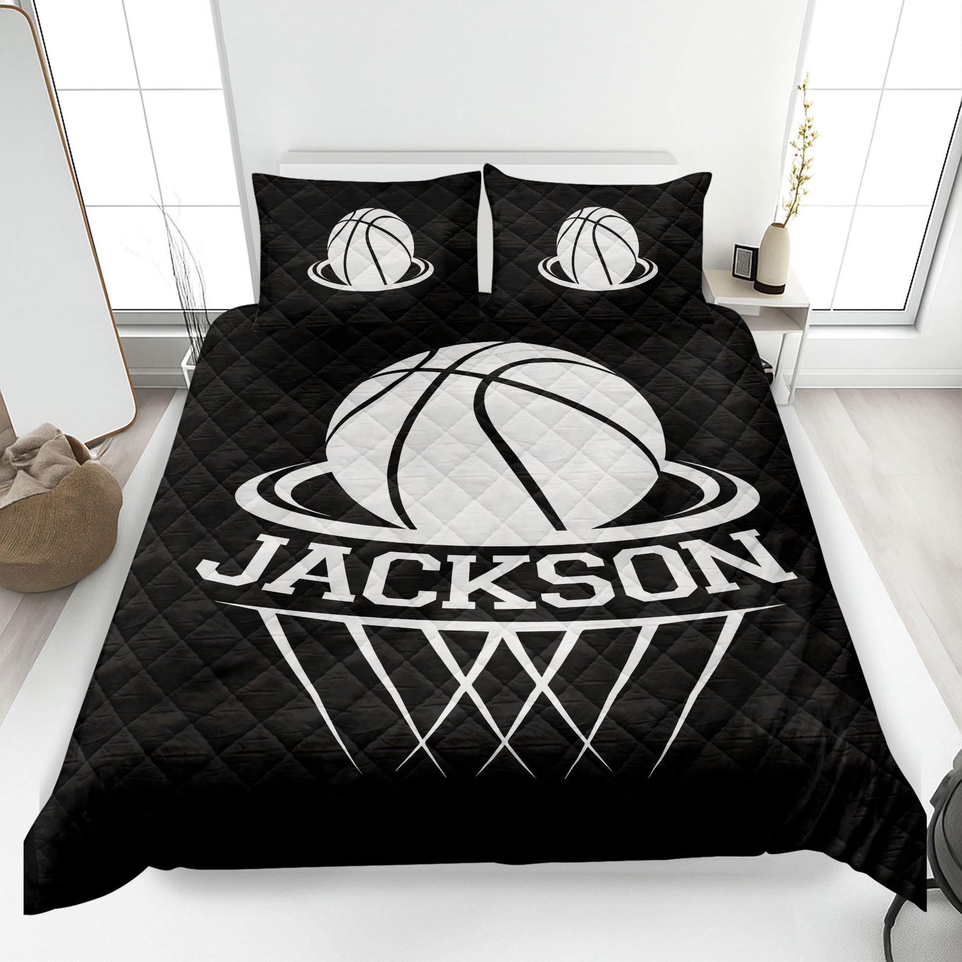 Black basketball quilt blanket styled on a bedroom bed with bold white sports artwork
