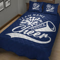 Close view of navy cheerleading quilt blanket with pom-pom and megaphone design
