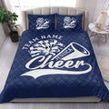 Navy cheerleading quilt blanket styled in a bright bedroom with matching cheer-themed pillows