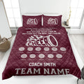 Maroon cheerleading quilt blanket featuring white megaphone and pom-pom artwork on a bed