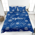 Blue cheerleading quilt blanket displayed on a bed with pom-poms, megaphones, and star accents