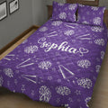 Close bedroom view of a purple cheerleading quilt blanket with pom-poms and megaphone artwork