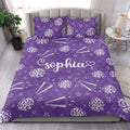 Purple cheerleading quilt blanket shown in a bright bedroom with pom-poms, megaphones, and stars