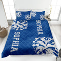 Blue cheerleading quilt blanket displayed on a bed with energetic pom-pom graphics
