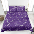 Purple hockey quilt blanket styled on a bedroom bed with hockey sticks and puck pattern