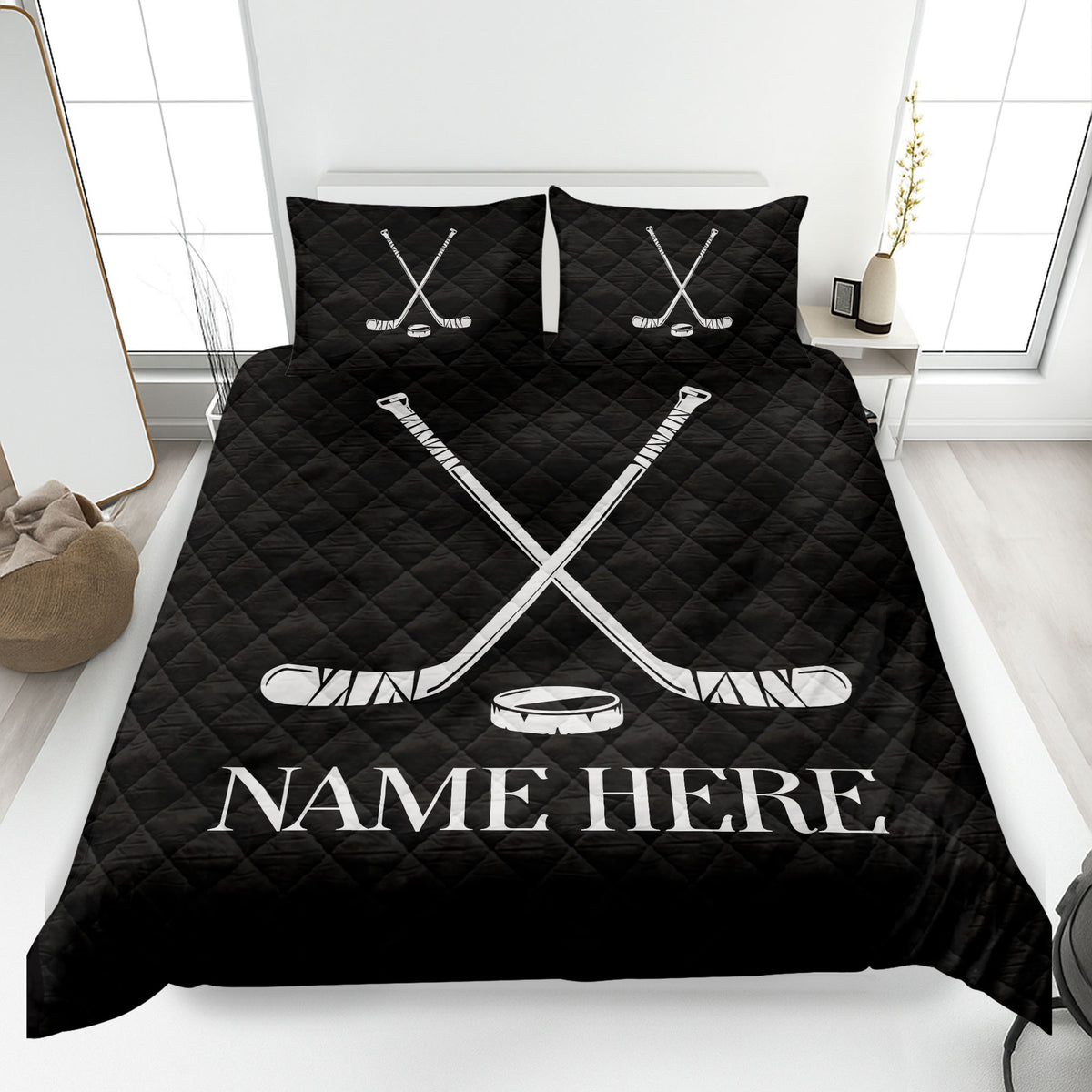 Black hockey quilt blanket displayed on a bed with bold white crossed sticks and puck design