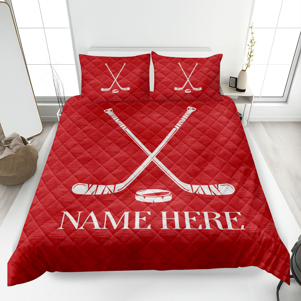Red hockey quilt blanket on a bed featuring white crossed hockey sticks and puck artwork