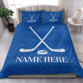 Blue hockey quilt blanket presented in a bright bedroom with crossed sticks and puck design