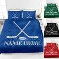 Blue hockey quilt blanket displayed on a bed with crossed sticks, puck artwork, and alternate color views