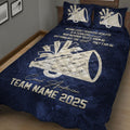 Close view of navy cheerleading quilt blanket featuring megaphone graphics, cheer bows, and team artwork
