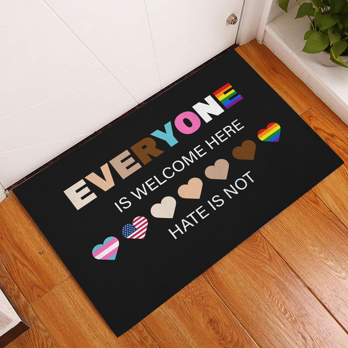 LGBT entryway rug displayed on a wood floor beside a white door