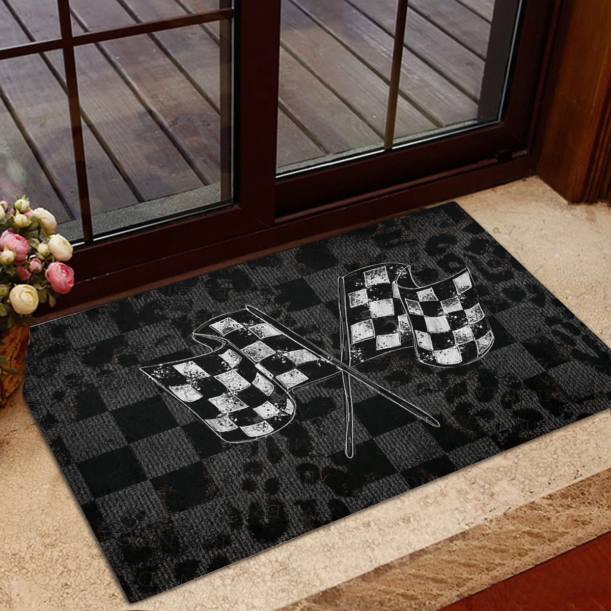 Crossed checkered racing flag doormat displayed near a glass entry door