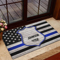 Police badge doormat placed at an interior doorway with a blue stripe flag design
