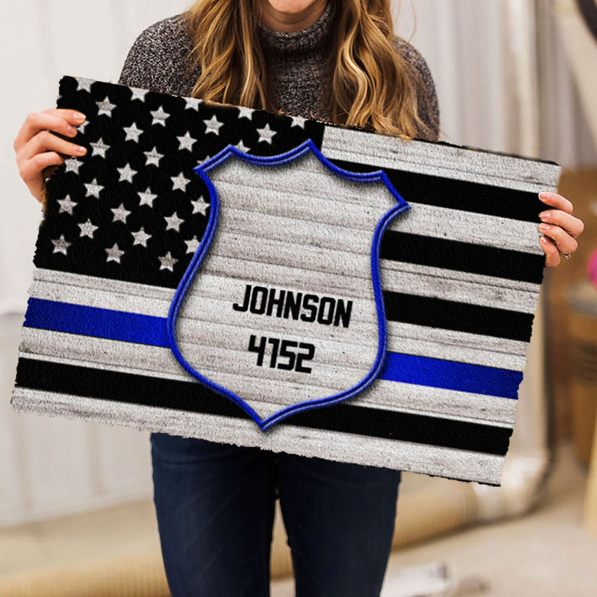 Person holding a police badge doormat featuring a stars and stripes flag pattern
