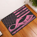 Pink ribbon breast cancer doormat displayed at a home entrance on a wood floor