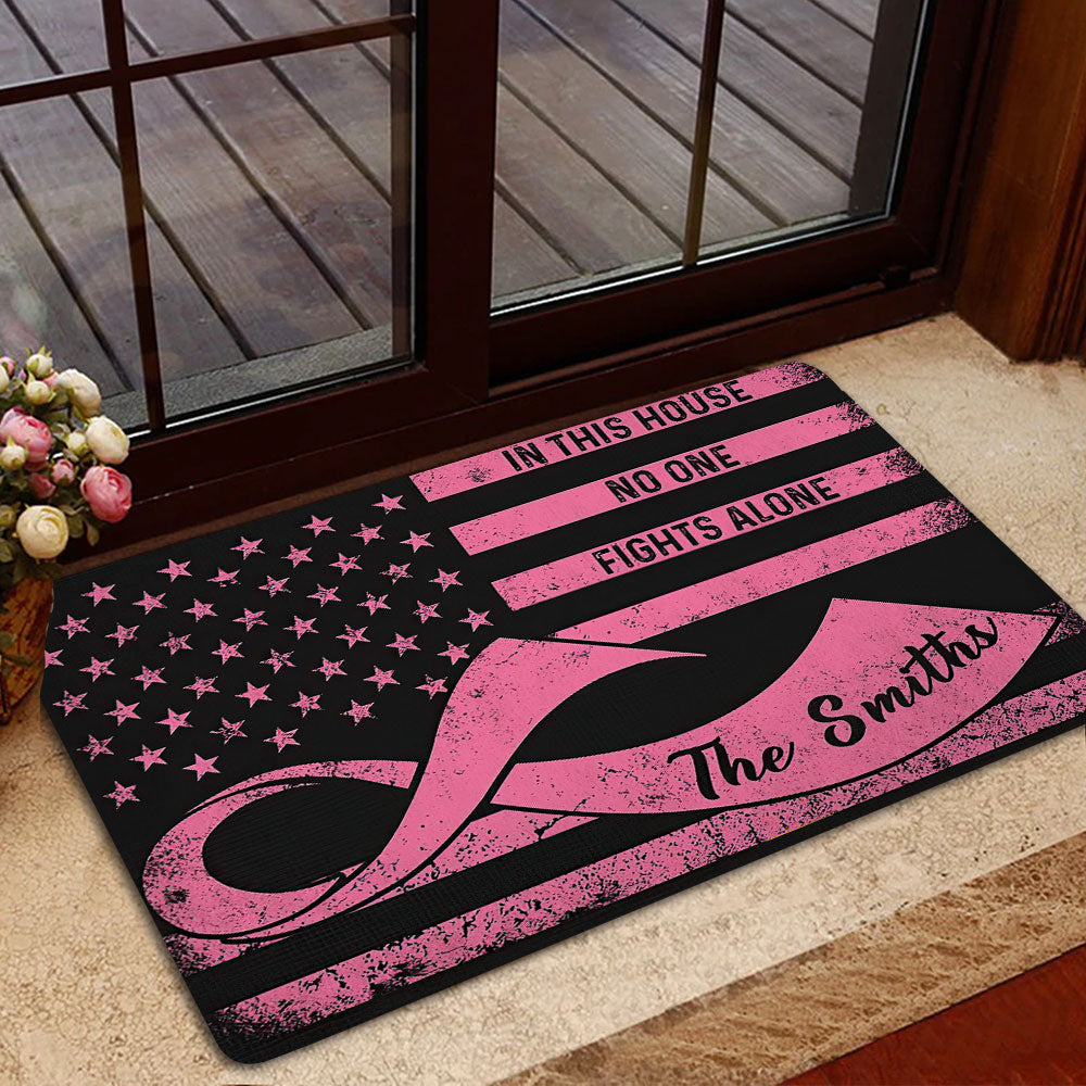 Pink ribbon breast cancer doormat styled in a welcoming indoor entryway near a glass door