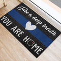 Blue line police doormat positioned beside a doorway with a heart and badge design